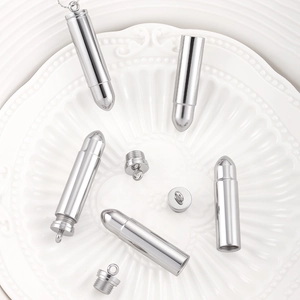 Detailed macro of polished stainless steel bullet pendant with a screw-open lid and ring