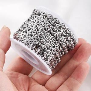 Silver stainless steel bead and link chain on a white spool for DIY jewelry making