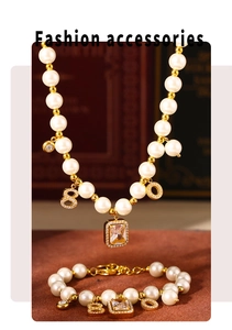 Detail of vintage pearl necklace and bracelet set with numeric pendants and crystals