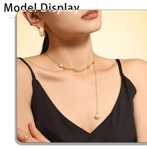 Detail of elegant gold wheat-leaf necklace with pearl pendant worn by a model