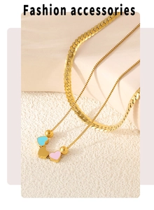Détail du collier doré multi-rangs avec cœurs en émail coloré et chaîne serpent