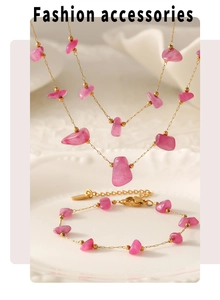 Close-up of pink natural stone necklace and bracelet set on a white vintage plate