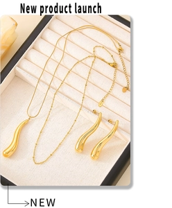 Vue détaillée du collier pendentif goutte d'or et des boucles d'oreilles sur plateau