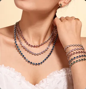 Layered gold necklaces and bracelets with colorful round zircons on female model