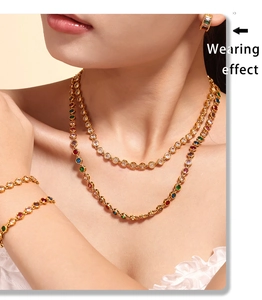 Close-up of model wearing layered gold necklaces and bracelets with colorful zircon beads
