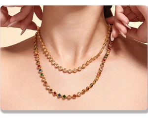 Detail of layered gold-plated necklaces with vibrant colorful zircons on a female neck