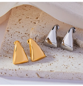 Macro detail of geometric triangle titanium steel earrings in gold and silver finishes