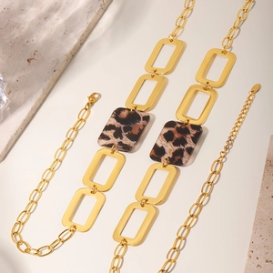 Close-up of golden rectangular link necklace featuring trendy acrylic leopard print charms