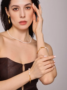 Dettaglio del set di gioielli con perle d'acqua dolce e accenti in oro opaco su modella