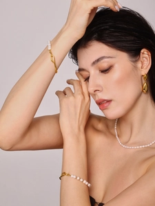 Dettaglio della collana di perle d'acqua dolce barocche e orecchini su una modella