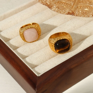 Detail of vintage gold textured rings featuring pink quartz and tiger eye stones