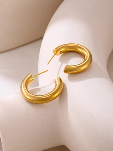 Polished 18k gold-plated C-shaped chunky hoop earrings on minimalist display stand