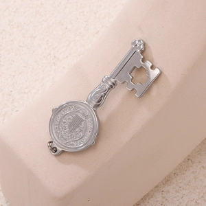 Close-up of vintage silver Saint Benedict key pendant with religious relief carving