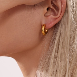 Polished 18k gold plated stainless steel C-shaped hoop earring worn on female ear
