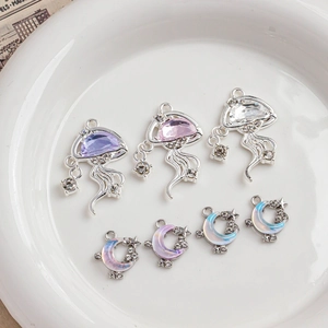 Detail of alloy jellyfish and crescent moon pendants with cubic zirconia for jewelry DIY