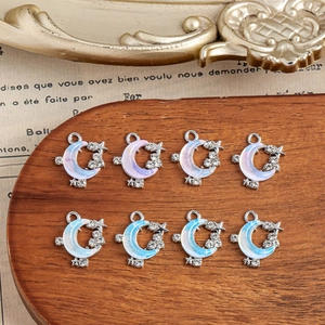 Macro detail of moon and star charms with colorful enamel and inlaid rhinestones