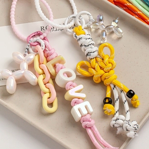 Colorful nylon rope keychains with LOVE beads and balloon dog charms on a beige tray