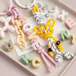Detail of macaron color handmade woven keychain with love letter beads and balloon dog
