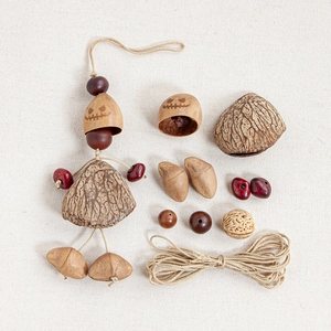 Flat lay of DIY Halloween craft kit with pumpkin shells, wood beads and hemp rope