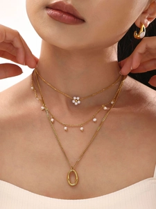 Dettaglio della collana a strati placcata oro 18K con perle di conchiglia e ciondoli
