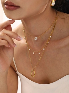 Dettaglio di collane multistrato placcate in oro 18 carati con perle sul collo di un modello