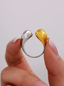 Macro shot of polished two-tone teardrop ring featuring gold and silver mirror finish