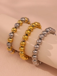 Gros plan de bracelets à billes de 10mm en acier inoxydable doré et argenté poli