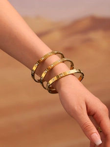 Close-up of three 18K gold plated stainless steel bangles with square zircon inlays