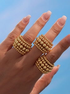 Detail of 18k gold plated five-layer beaded adjustable ring worn on fingers