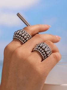 Close-up of a tiered silver beaded ring on model hand with a scenic blue sky backdrop