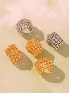Close-up of multi-layer beaded ear cuffs in polished gold and silver finishes