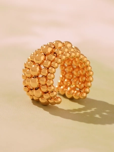 Macro detail of multi-row gold beaded ring with woven metallic structure and 18k finish