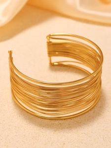 Dettaglio macro del bracciale rigido dorato multistrato con elegante finitura metallica