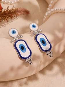 Détail de boucles d'oreilles bohèmes œil protecteur en émail bleu sur support élégant