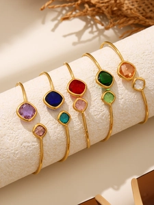 Detail of five gold-plated bangles set with colorful square Czech glass stones