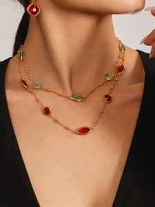 Detail of 18k gold plated double necklace set with red and blue faceted glass stones