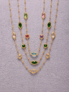 Detail of multi-layered 18k gold-plated bead necklace with vibrant faceted glass stones