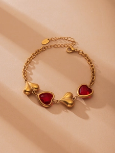 Detalle de pulsera de acero inoxidable bañada en oro 18k con corazones de cristal checo