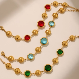 Detail of gold beaded anklet with colorful Czech glass charms and lobster clasp closure