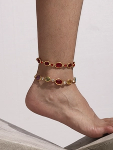 Close-up of bohemian gold anklet set with colorful Czech glass stones on an ankle