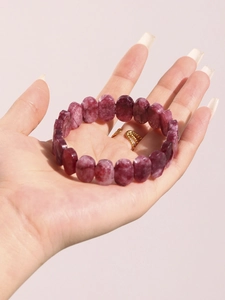 Gros plan d'un bracelet élastique en pierre naturelle violette avec des perles texturées