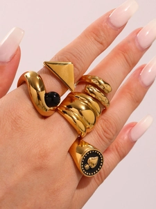Set of five gold-plated chunky geometric rings with black bead and heart seal detail