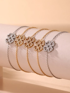 Vista dettagliata di cinque bracciali a quadrifoglio con zirconi in oro e argento