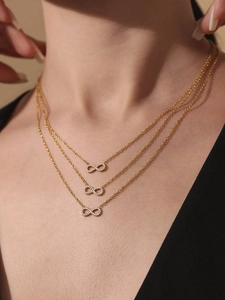 Gros plan du collier triple rang plaqué or 18 carats avec symboles infini et zircons brillants