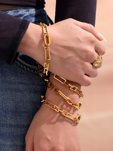 Detail eines 18k vergoldeten Kettenglied-Armbands und rechteckigen Diamantrings