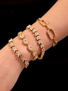 Detailed view of four 18k gold plated bracelets with 5A cubic zirconia on wrist