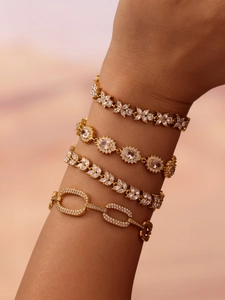Detail of four 18K gold plated stainless steel bracelets with cubic zirconia on a wrist