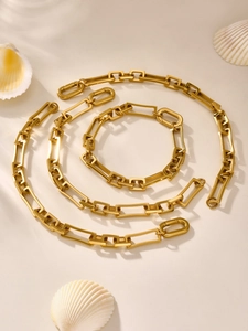 Detailansicht der 18k vergoldeten geometrischen Gliederkette auf einer weißen Muschel