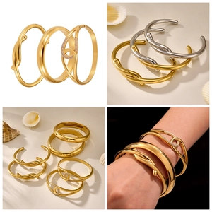 Close-up of 18k gold plated geometric bangles with twisted design and pavé rhinestones