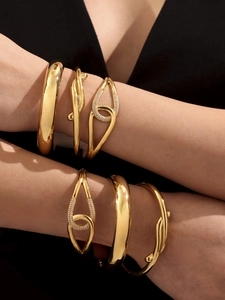 Macro shot of 18k gold plated geometric bracelets featuring hollow and twisted textures